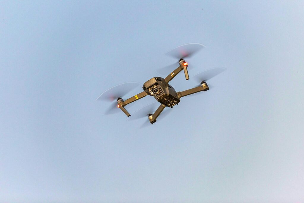 Aerial view of a drone in motion against a blue sky, illustrating modern technology in action.