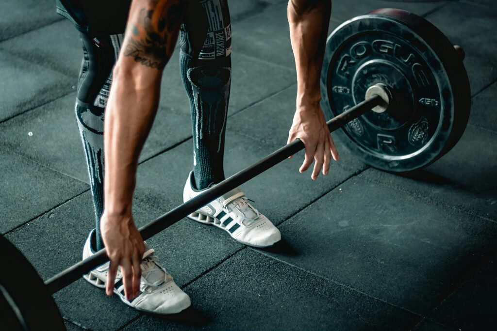 Focused athlete preparing to lift a heavy barbell. Indoor gym setting.