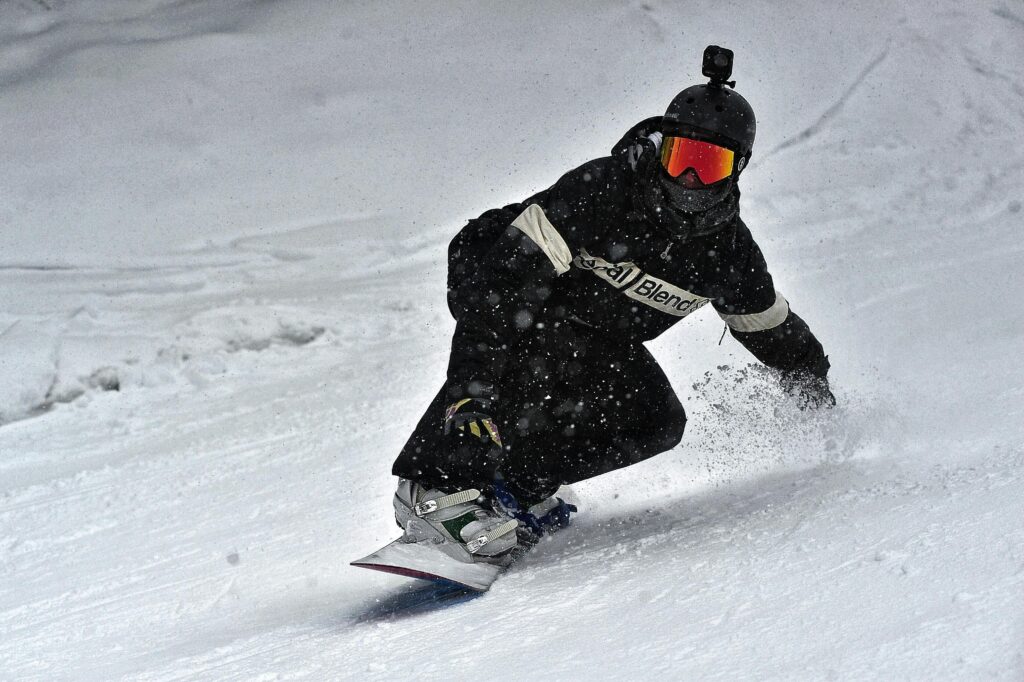A skier in full gear carving through fresh snow on a winter slope, showcasing speed and skill.