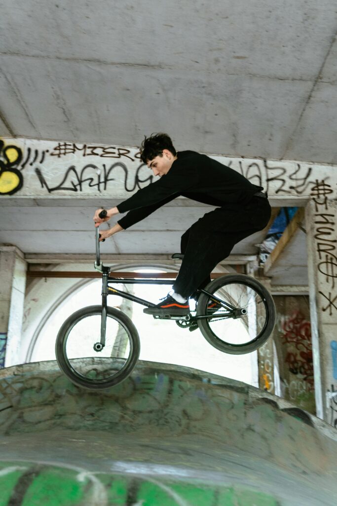 A skilled BMX rider performing tricks on a ramp in an urban skatepark with graffiti background.