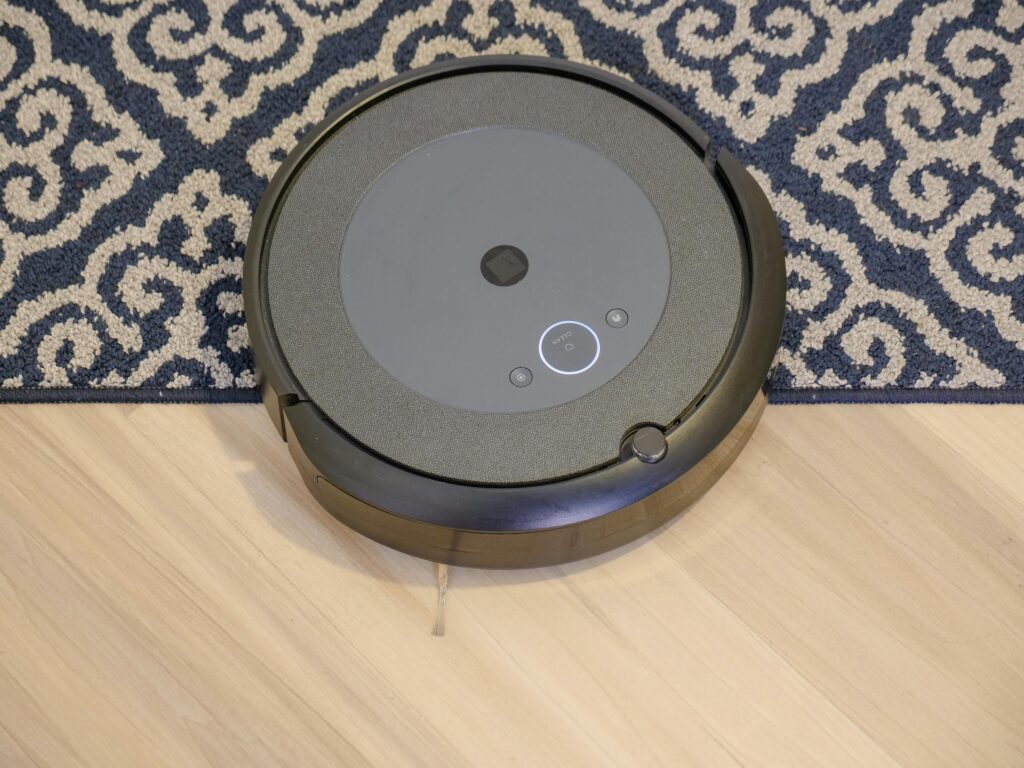 Modern robotic vacuum cleaner on a patterned carpet for efficient cleaning.