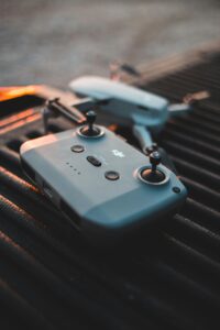 Close-up of a drone controller and drone in a dramatic sunset setting.
