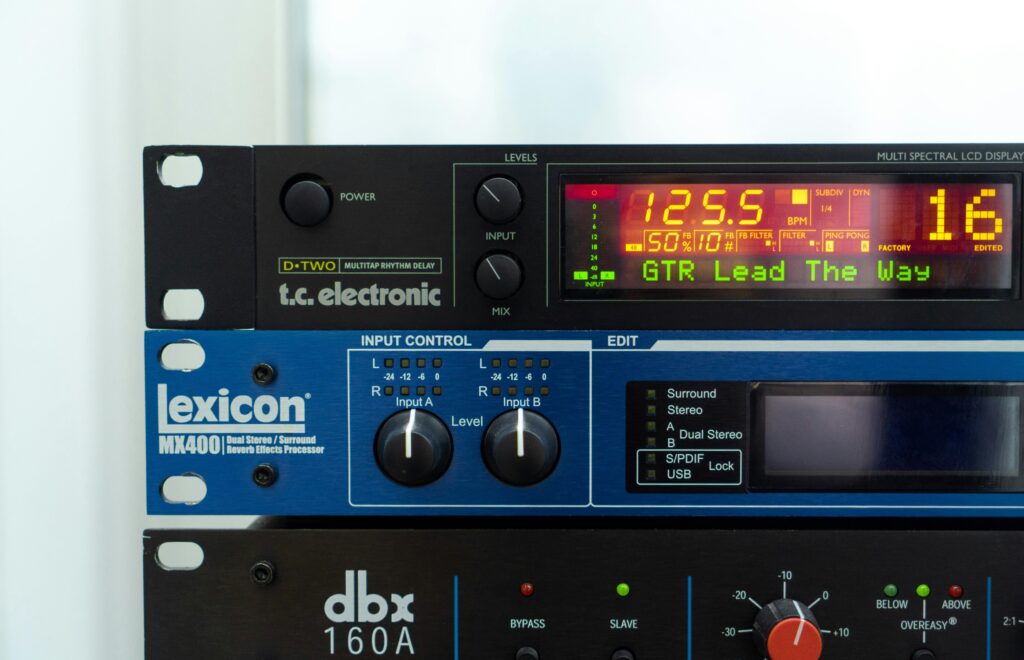 Stacked audio processors in a studio rack with digital displays and controls.