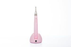 Dental handpiece device in pastel pink isolated on white for clinical use.