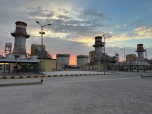 A striking view of an industrial factory during sunrise in Saudi Arabia with a colorful sky.