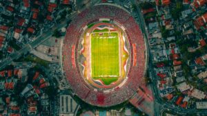Vibrant aerial shot of a packed football stadium with panoramic cityscape.