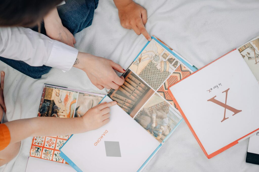 Top view of children exploring colorful illustrated books, fostering learning and interaction.