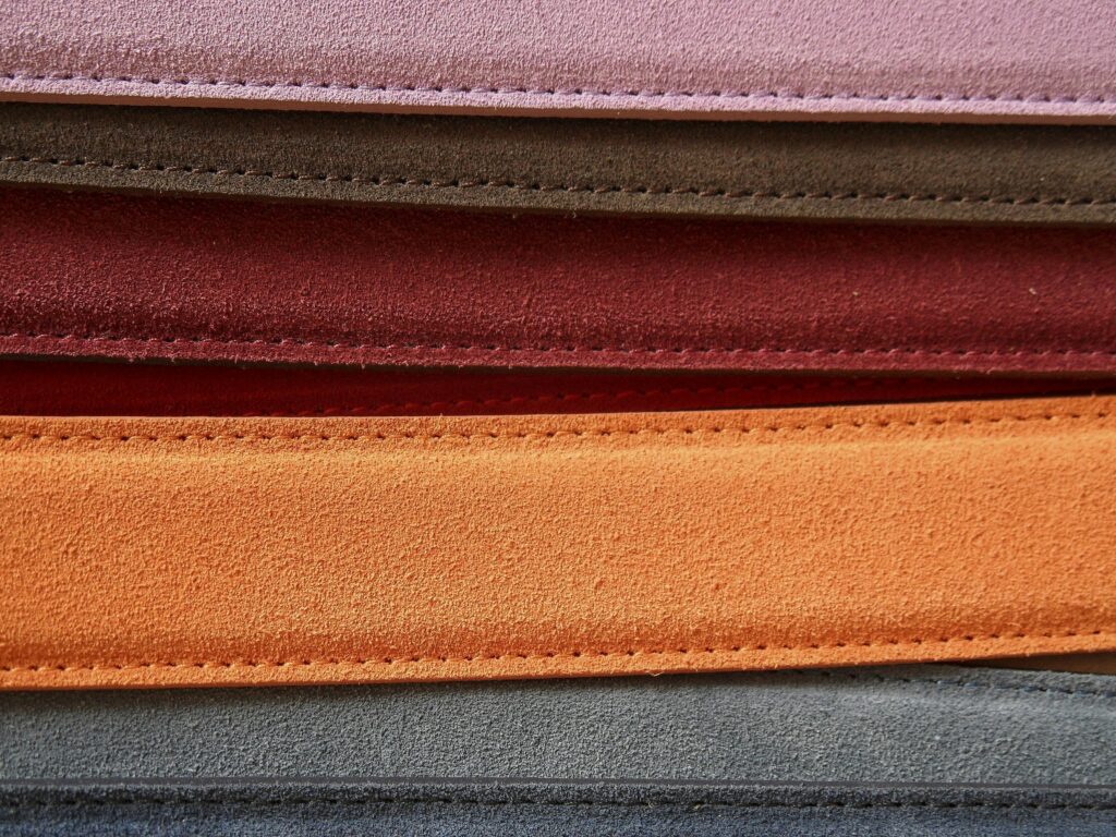 Close-up of colorful leather belts showcasing detailed stitching.
