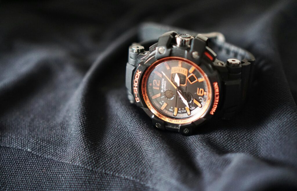 Close-up of a G-Shock sports watch with an analog display, resting on black fabric.