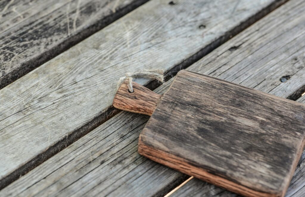 A rustic wooden cutting board on a vintage wood table, offering a natural aesthetic.