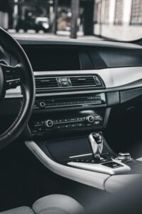 High-end car interior showcasing a sleek gear shift and advanced dashboard controls.