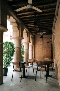 Rustic outdoor café with brown chairs and tables under a covered patio, perfect for a quiet retreat.