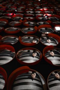 Abstract reflective art installation featuring multiple round mirrors in red frames.