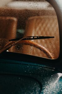 Close-up of a classic car's windscreen with raindrops highlighting the vintage aesthetic.