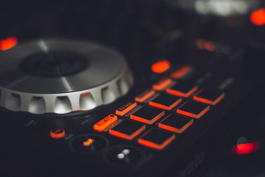 Close-up of a DJ controller with illuminated buttons and control knobs, ideal for music technology themes.