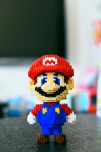 A pixelated building block toy of a famous video game character with a blurred background.