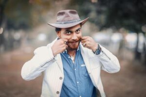 Smiling man in a cowboy hat poses playfully outdoors, Lahore, Pakistan.