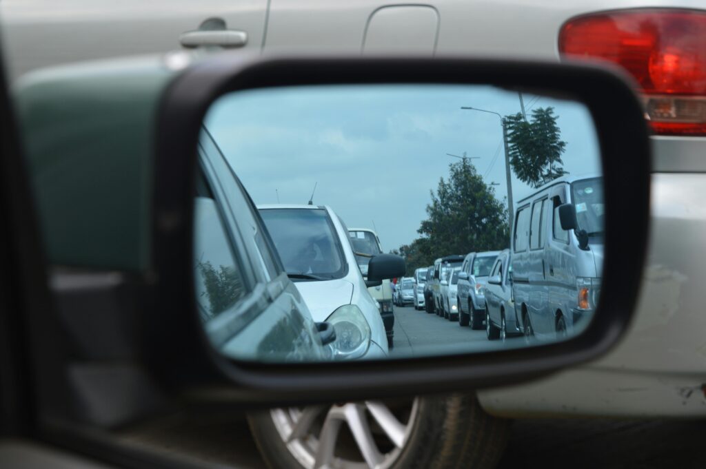 Reflection of a busy traffic jam in Nairobi captured through a car's side mirror.