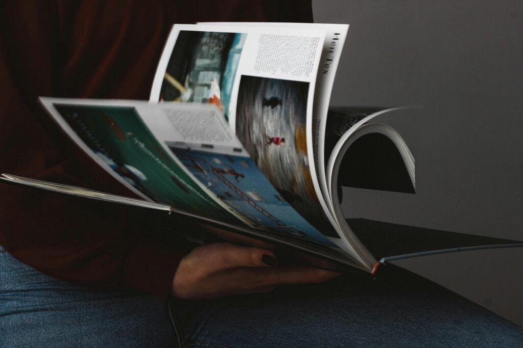 A person flips through a photography book, emphasizing the visuals.