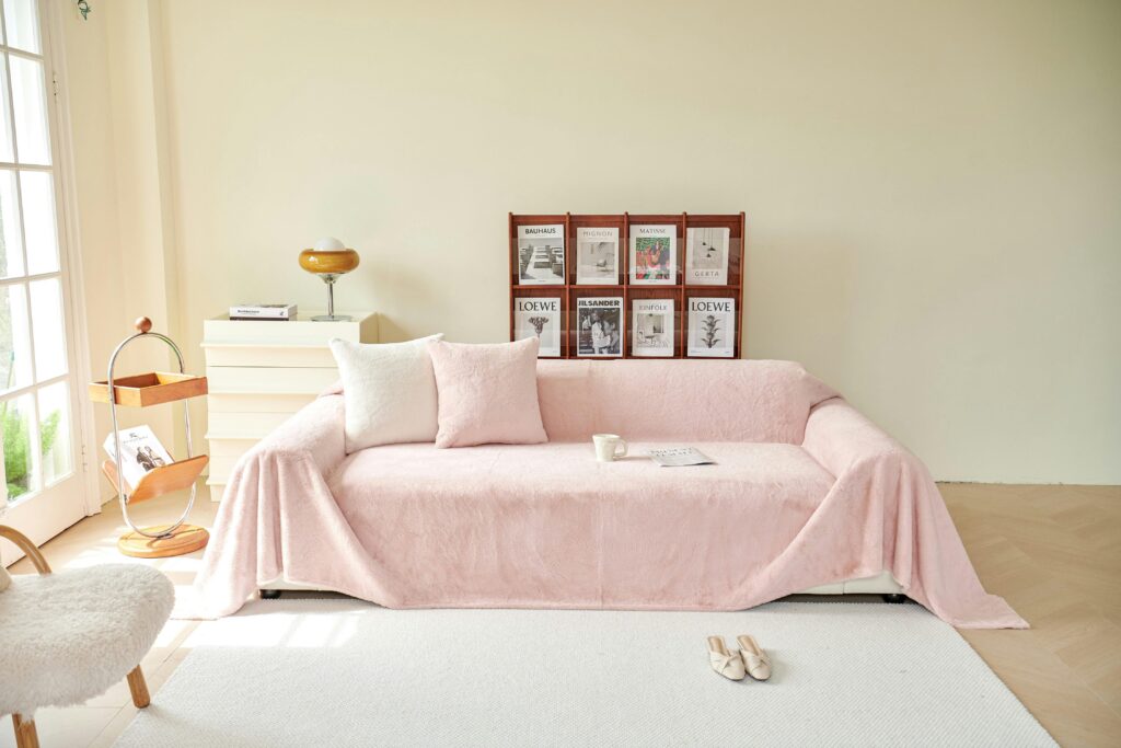 Chic living room featuring a pink covered sofa, elegant decor, and modern furnishings, creating a serene ambiance.