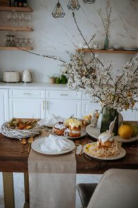Elegant Easter table setup with cakes and blooming branches in a modern kitchen.