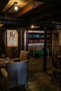 Warm vintage interior of a rustic library in Malta with cozy seating and wooden beams.