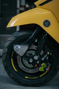 Close-up of a yellow motorcycle wheel showing detailed brake caliper design.