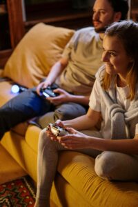 Young couple playing video games at home, enjoying leisure time together.