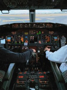 Interior of a cockpit with pilots operating controls, showcasing advanced avionics and flight instruments.