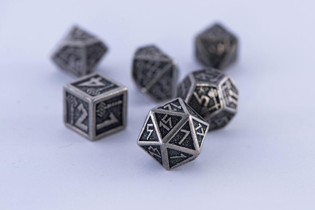 Metal polyhedral dice set displayed on a white surface. Perfect for tabletop gaming enthusiasts.