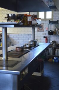 Empty commercial kitchen with stainless steel surfaces and cooking equipment.