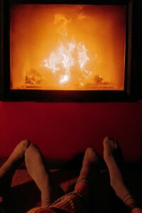 A warm, romantic moment by the fire with cozy socks and gentle lighting.