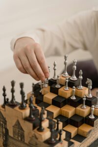 Close-up of a hand making a chess move on a unique step chessboard.
