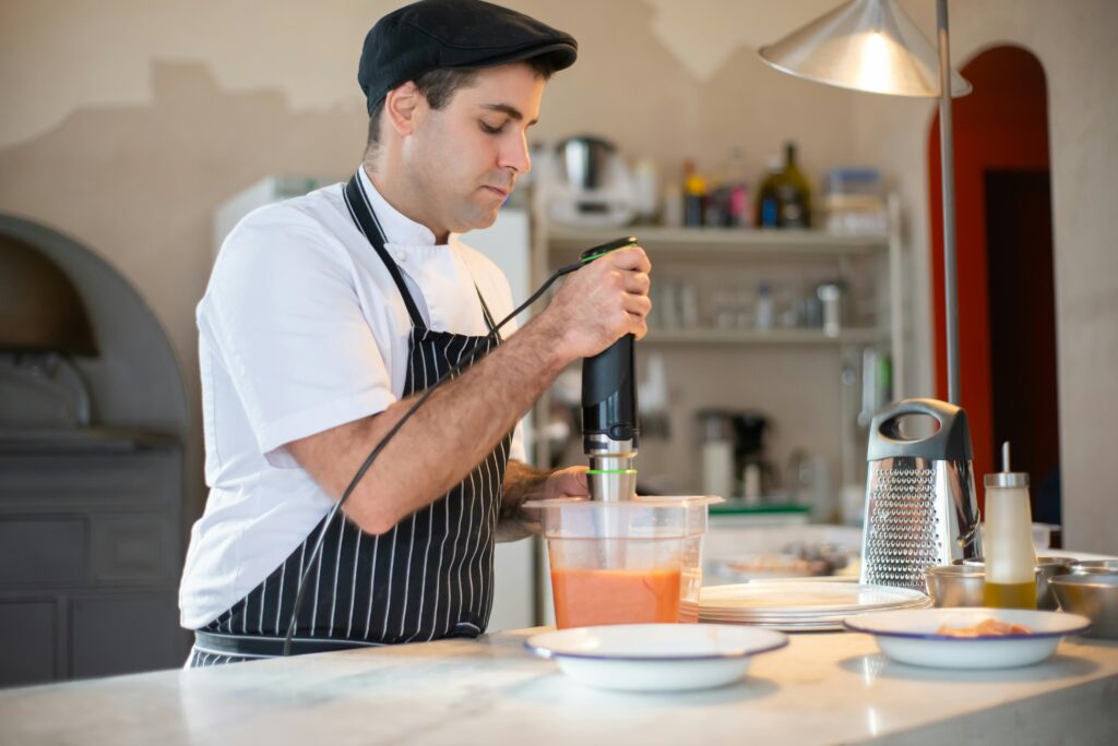 A chef skillfully blending ingredients in a contemporary kitchen setting.