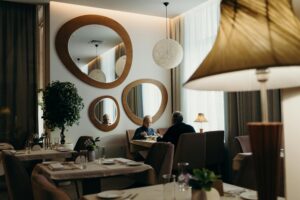 Elderly couple enjoying a meal in a cozy, stylish restaurant with modern decor.