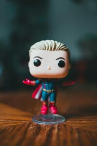 A vibrant superhero action figure standing on a wooden surface in bright lighting.