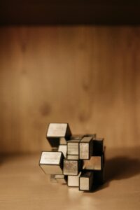 Close-up of a metal geometric puzzle on a wooden background showcasing depth of field.