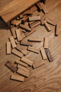 An artistic shot of scattered wooden blocks on a wooden surface creating a textured pattern.