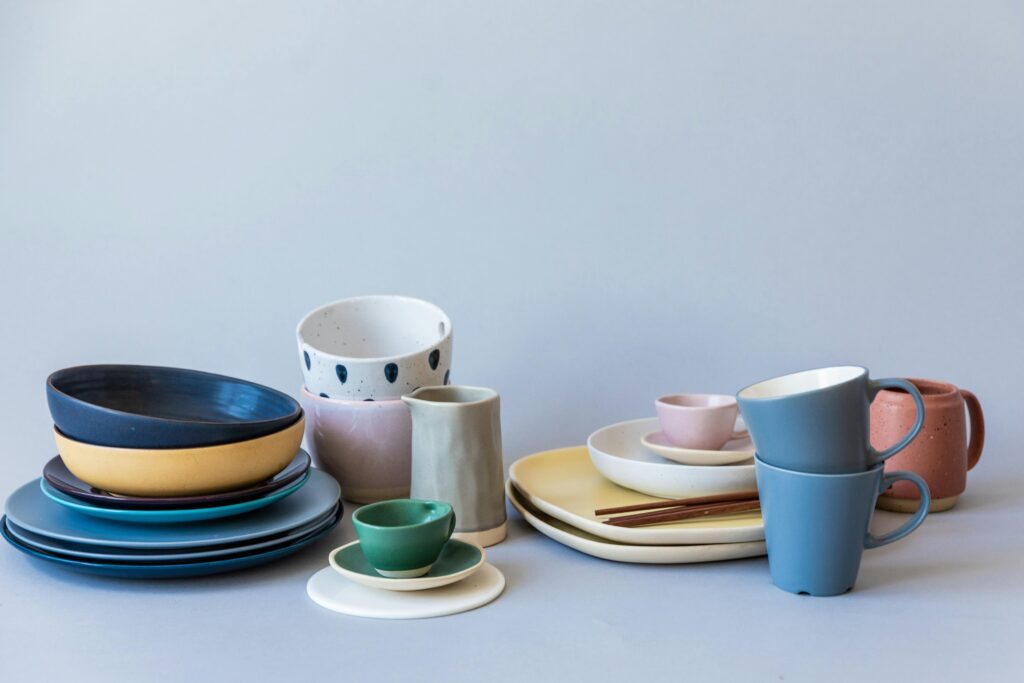 Assorted ceramic tableware displayed elegantly on a light backdrop, showcasing vibrant colors and textures.