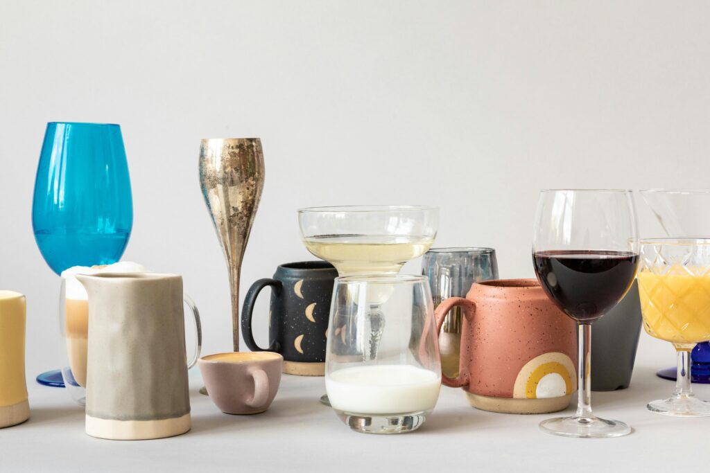 A variety of ceramic and glass drinkware on a light background.