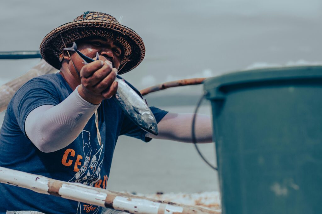 A fisherman in Ginatilan, Philippines holds a fresh fish, showcasing traditional livelihood.